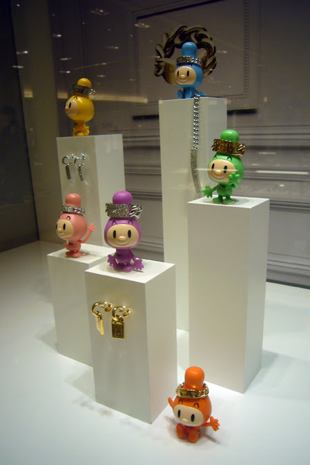 Gourmette-chan figures wearing Dior rings in a boutique display